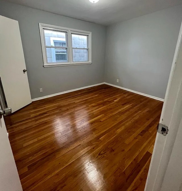 unfurnished room with dark hardwood / wood-style flooring