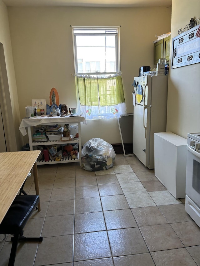 kitchen featuring white appliances, light tile patterned flooring, and light countertops