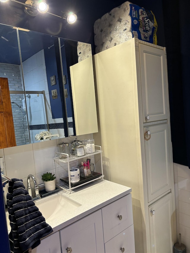 bathroom featuring decorative backsplash, tile walls, a shower stall, and vanity