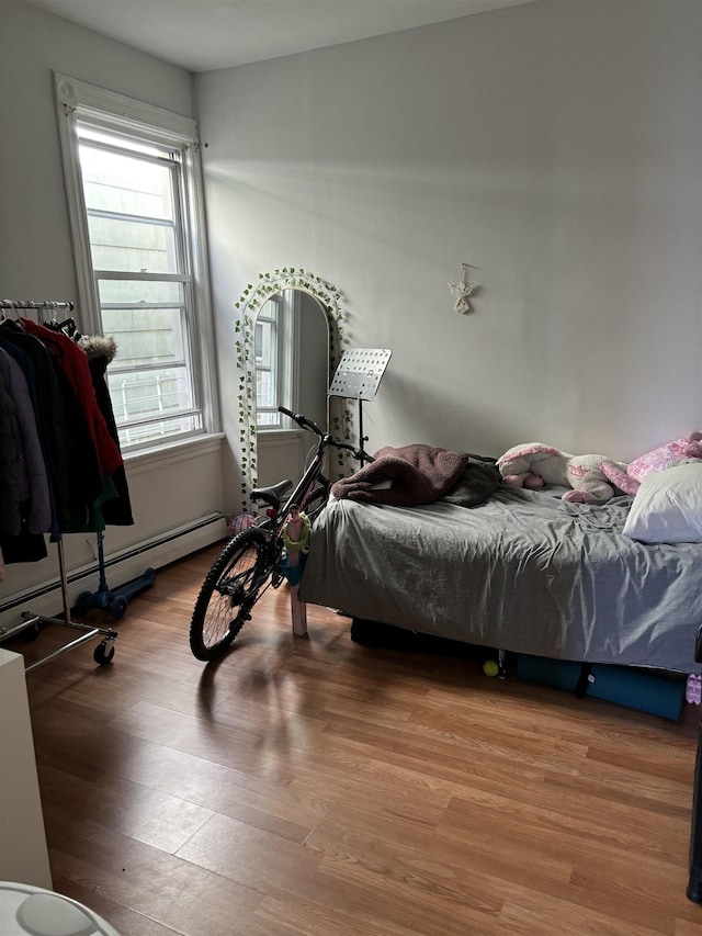 bedroom featuring a baseboard radiator and wood finished floors