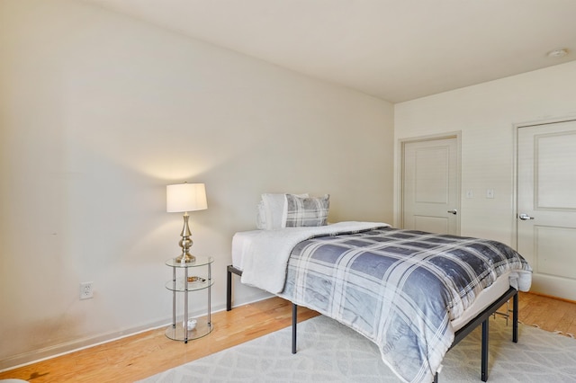 bedroom featuring wood finished floors and baseboards