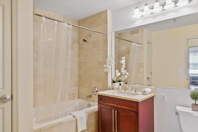 bathroom featuring tiled shower / bath combo, vanity, and toilet
