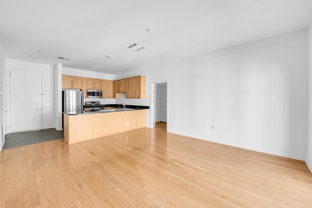 1300 Grand St Unit 521, Hoboken, NJ 07030 - kitchen featuring stainless steel appliances, open floor plan, light wood-type flooring, dark countertops, and a sink
