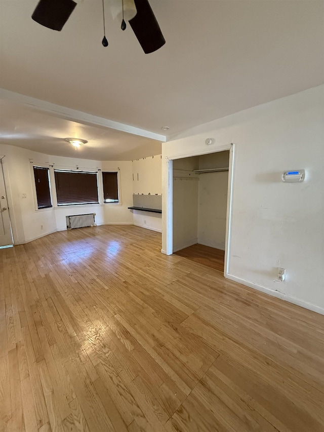 78 W 27th St, Bayonne, NJ 07002 - unfurnished living room featuring radiator, a ceiling fan, light wood-style floors, and baseboards