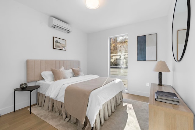 391 1st St Unit 3-B, Jersey City, NJ 07302 - bedroom featuring a wall unit AC, wood finished floors, and baseboards