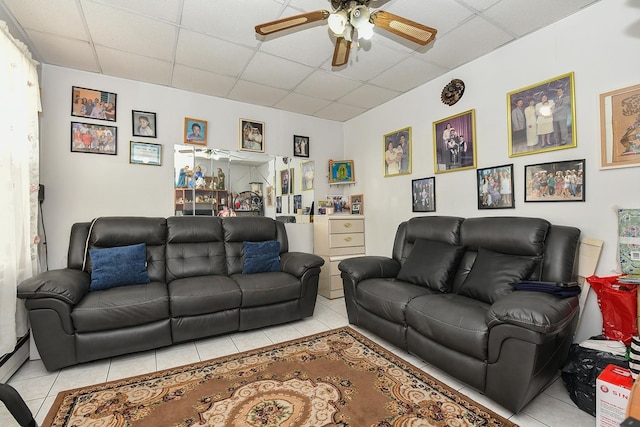 living area featuring a paneled ceiling, ceiling fan, and light tile patterned floors
