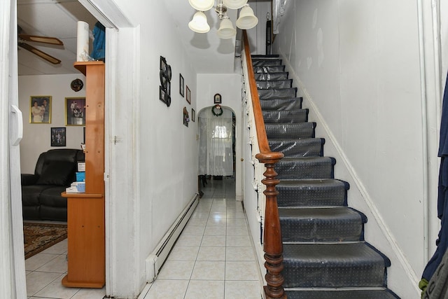 staircase featuring a ceiling fan, tile patterned flooring, and a baseboard radiator