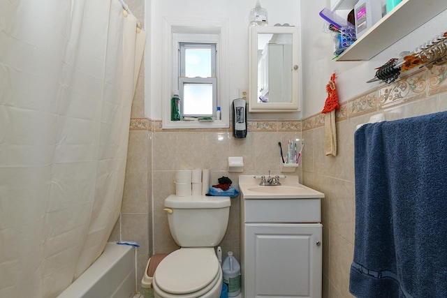 bathroom featuring shower / bath combination with curtain, toilet, vanity, tile walls, and wainscoting