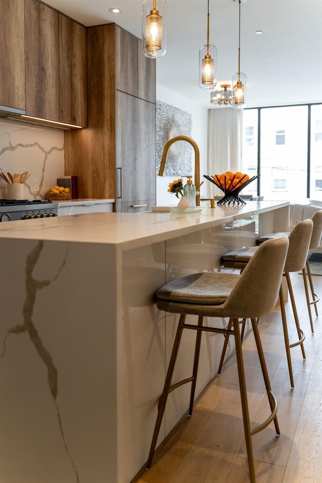48 Coles St Unit 2, Jersey City, NJ 07302 - kitchen featuring modern cabinets, brown cabinetry, decorative light fixtures, light wood-style flooring, and recessed lighting