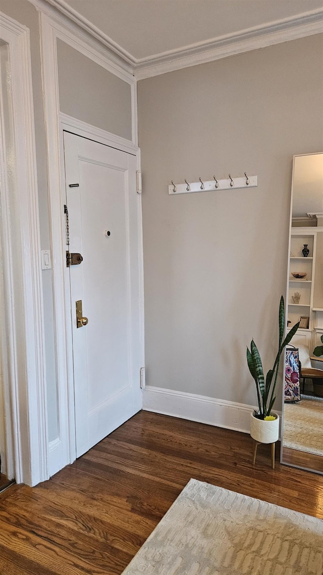 entrance foyer featuring crown molding, baseboards, and dark wood finished floors