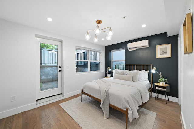 20 Storms Ave Unit 1A, Jersey City, NJ 07306 - bedroom with a wall unit AC, wood finished floors, baseboards, recessed lighting, and a chandelier