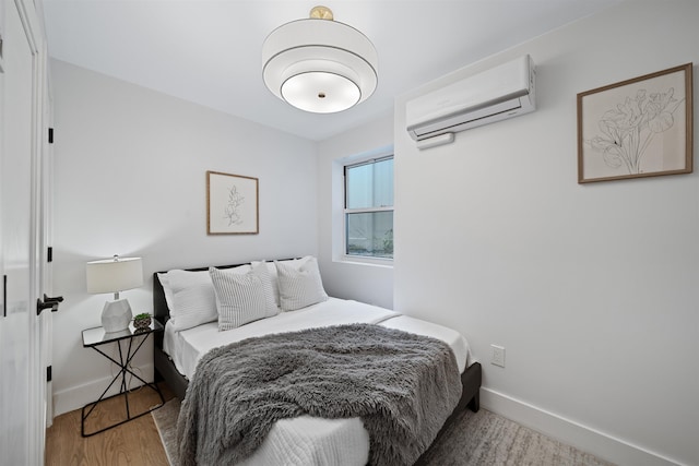 20 Storms Ave Unit 1A, Jersey City, NJ 07306 - bedroom with a wall mounted AC, baseboards, and wood finished floors