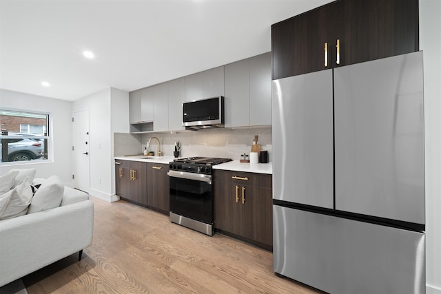 20 Storms Ave Unit 1A, Jersey City, NJ 07306 - kitchen with stainless steel appliances, light countertops, light wood-type flooring, backsplash, and a sink