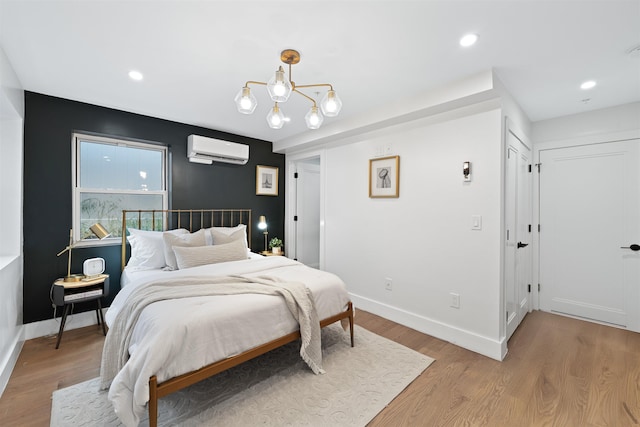 20 Storms Ave Unit 1A, Jersey City, NJ 07306 - bedroom with an AC wall unit, a chandelier, light wood-type flooring, baseboards, and recessed lighting