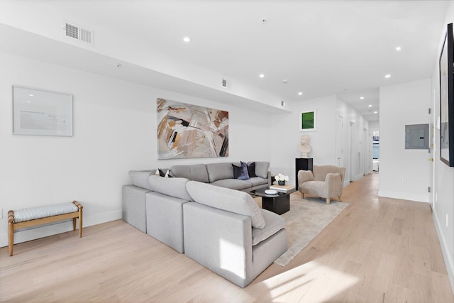 living room featuring recessed lighting, visible vents, light wood-style flooring, and electric panel