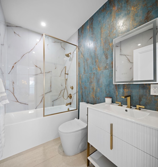 bathroom featuring vanity, toilet, tile walls, and  shower combination