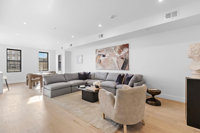 living room featuring recessed lighting, visible vents, and light wood-style flooring