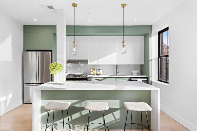 kitchen with tasteful backsplash, appliances with stainless steel finishes, modern cabinets, and a sink