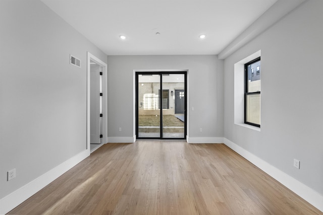 spare room featuring light wood-style floors, baseboards, and recessed lighting