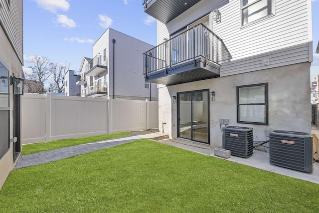 view of yard featuring central air condition unit and a balcony