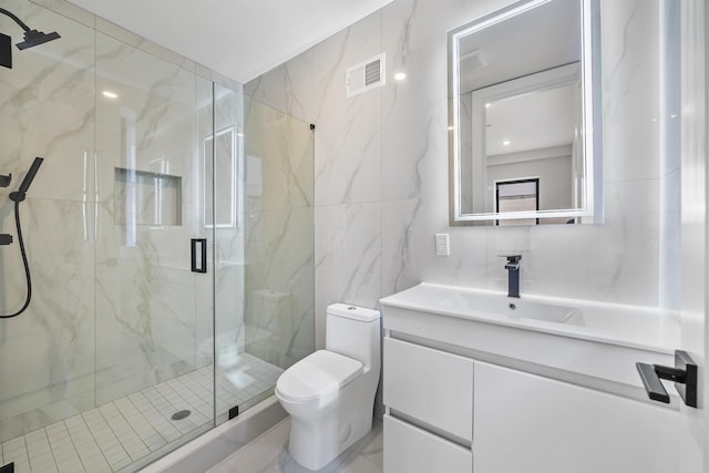 bathroom featuring tile walls, toilet, a marble finish shower, and vanity