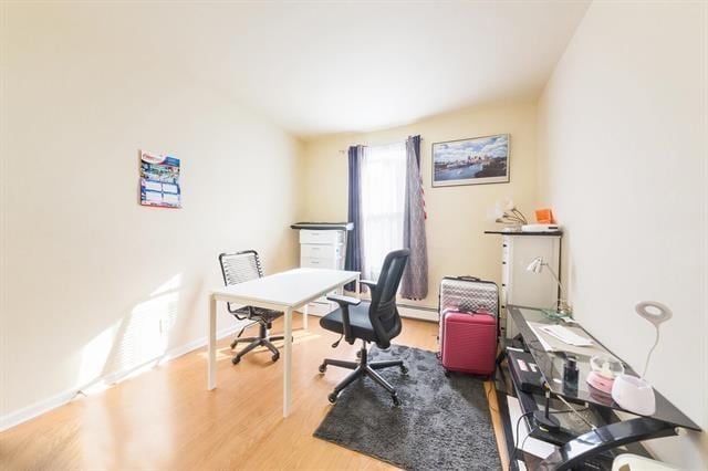 office with hardwood / wood-style floors and baseboard heating