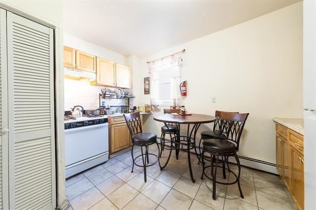 kitchen featuring white gas stove and light tile patterned floors