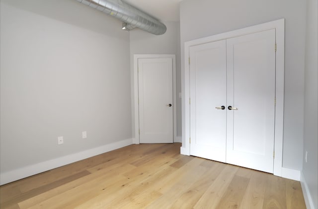 unfurnished bedroom with a closet and light hardwood / wood-style flooring