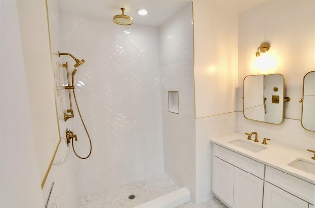 bathroom featuring a tile shower and vanity