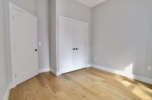 unfurnished bedroom featuring light hardwood / wood-style floors and a closet