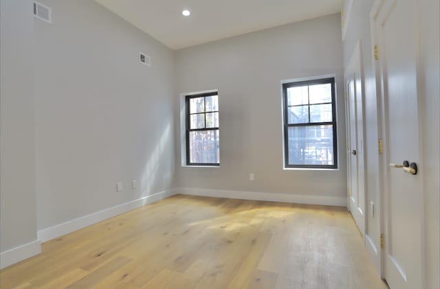 spare room featuring plenty of natural light and light hardwood / wood-style flooring