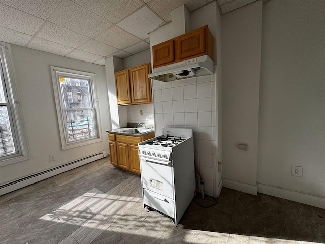 kitchen with a drop ceiling, plenty of natural light, gas range gas stove, and baseboard heating