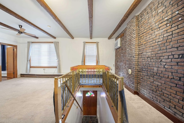 hallway with baseboard heating, beam ceiling, brick wall, and carpet