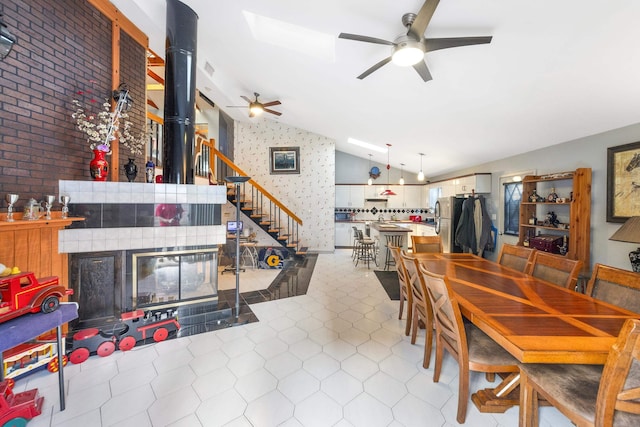 dining area with lofted ceiling, light tile patterned floors, and ceiling fan