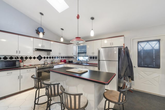 kitchen featuring white cabinetry, decorative light fixtures, and gas range oven