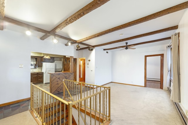 interior space with beam ceiling, light colored carpet, and baseboard heating