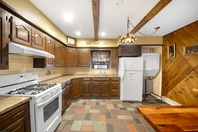 kitchen featuring sink, white appliances, stacked washing maching and dryer, tasteful backsplash, and beamed ceiling