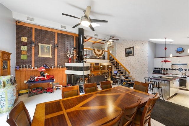 dining space featuring vaulted ceiling, light tile patterned floors, and ceiling fan