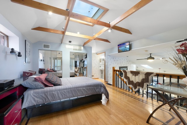 bedroom with hardwood / wood-style flooring and vaulted ceiling with skylight