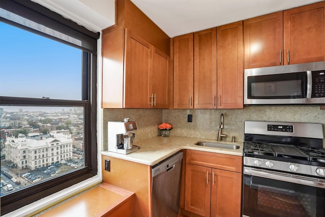 kitchen featuring brown cabinetry, light countertops, tasteful backsplash, a sink, and stainless steel appliances