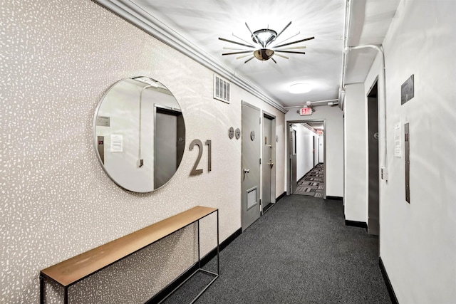 hallway featuring crown molding, baseboards, and visible vents