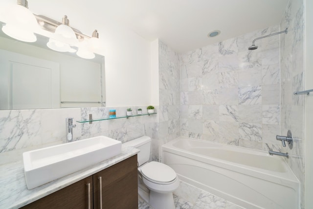 full bath featuring toilet, shower / tub combination, marble finish floor, vanity, and tile walls