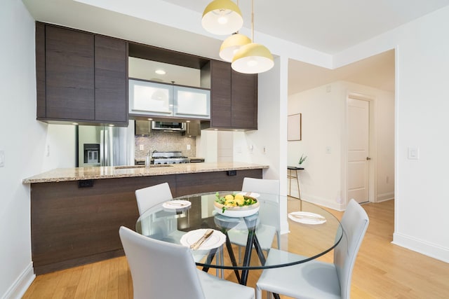 dining space featuring light wood-type flooring and baseboards