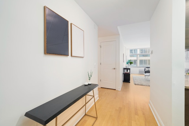 hallway featuring baseboards and light wood-style floors