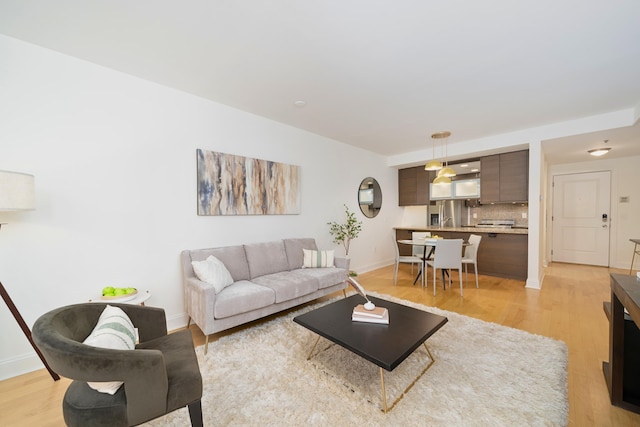 living area with baseboards and light wood finished floors