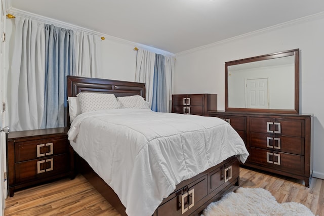 bedroom featuring ornamental molding and light wood-type flooring