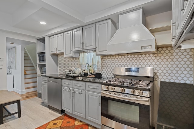 kitchen featuring custom exhaust hood, appliances with stainless steel finishes, sink, and gray cabinetry