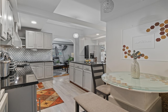 kitchen featuring tasteful backsplash, gray cabinets, stainless steel fridge, and light wood-type flooring