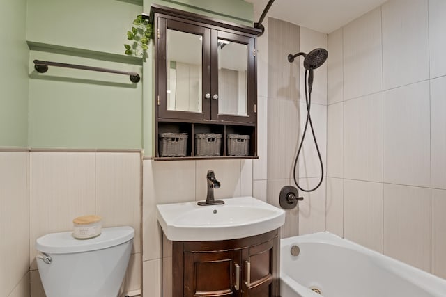 full bathroom with vanity, tile walls, toilet, and tiled shower / bath