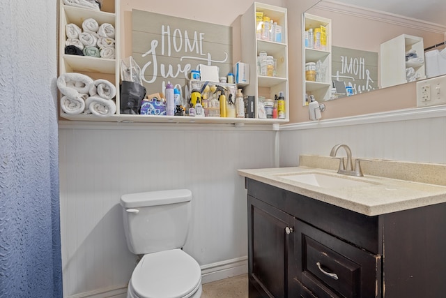 bathroom with crown molding, vanity, and toilet